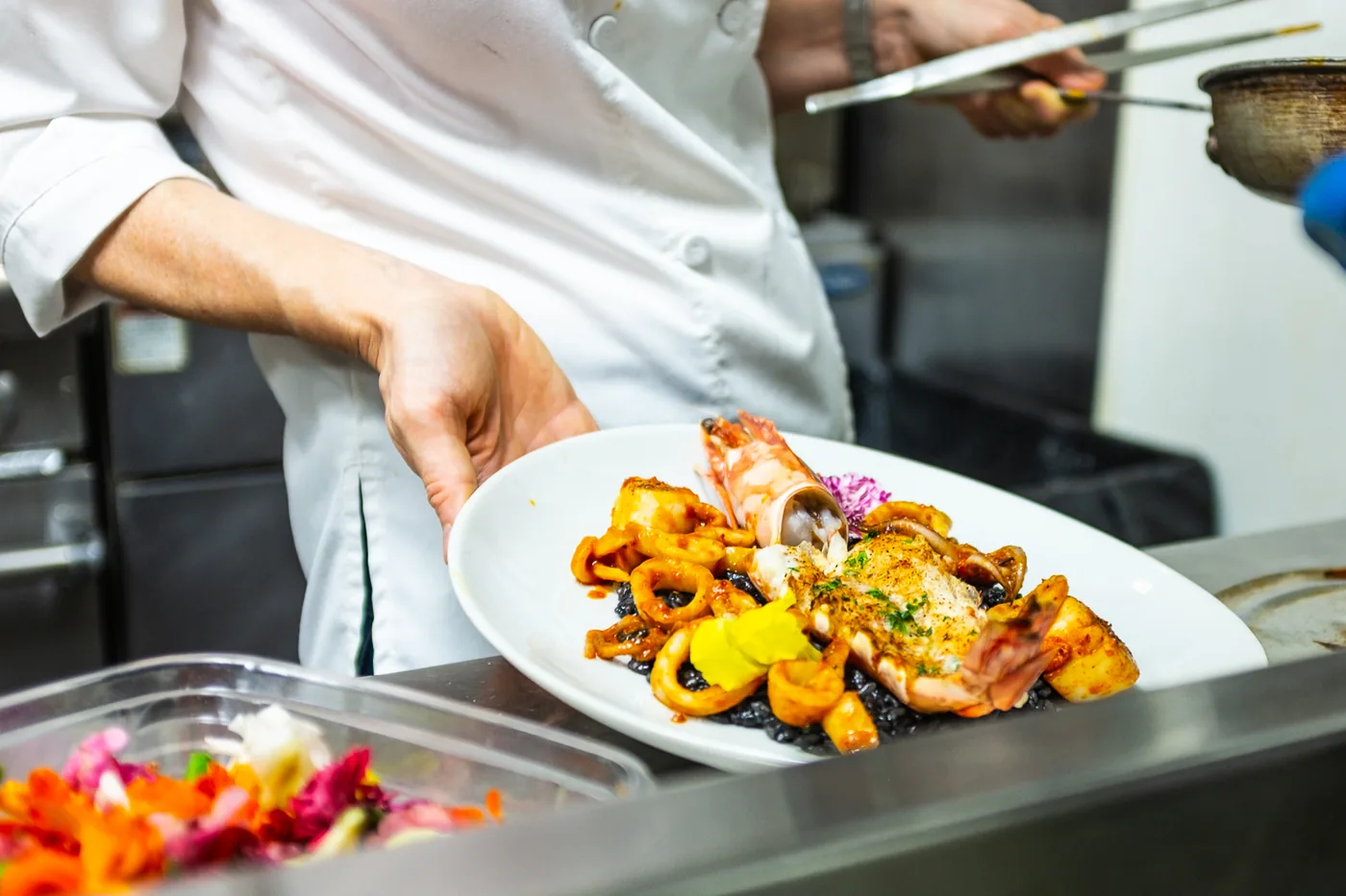 Plating black ink risotto with prawns in the Milano kitchen